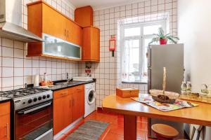 a kitchen with wooden cabinets and a stainless steel refrigerator at Garden View Apartment in Horta