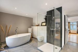 a bathroom with a tub and a glass shower at Klosterperle in Neuruppin +14 photos