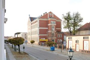 a city street with a large brick building and a street light at Klosterperle in Neuruppin