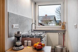 a small kitchen with a bowl of fruit on a table at Tinas Ferienwohnung in Hergensweiler