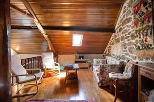 a living room with chairs and a stone wall at Casa do Largo in Mendiga