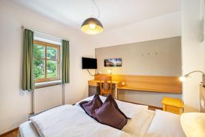 a bedroom with a bed and a desk and a window at Residence Grünbacher in Issengo