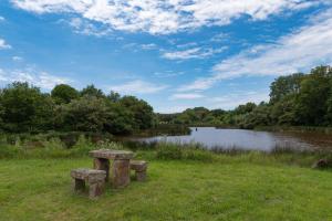 a field with two stone benches in front of a river at Sarzeau centre - Le Cormoran in Sarzeau