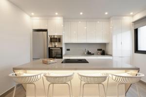 a kitchen with a large island with four bar stools at Apartamento Avenida Marítima in Candelaria