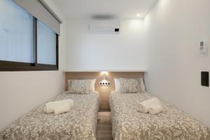 two beds in a room with white walls at Apartamento Avenida Marítima in Candelaria