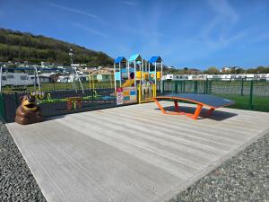 a playground with a slide and a play equipment at Spacious 2 bedroomed mobile home in Aberystwyth