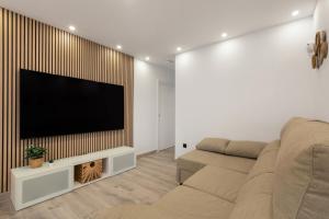 a living room with a couch and a flat screen tv at Apartamento Avenida Marítima in Candelaria
