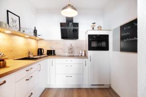a kitchen with white cabinets and a white refrigerator at Ferienwohnung Clara in Bremerhaven