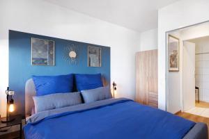 a bedroom with a blue bed with a blue wall at Ferienwohnung Clara in Bremerhaven