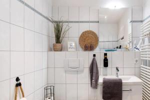 a bathroom with white tiled walls and a sink at Ferienwohnung Clara in Bremerhaven +12 photos
