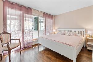 a bedroom with a bed and a chair and windows at Casa Deti in Roses