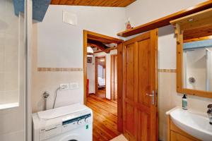 a bathroom with a washer and dryer and a sink at Appartamento Palmina in Falcade +17 photos