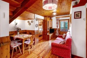 a living room with a red couch and a table at Appartamento Palmina in Falcade