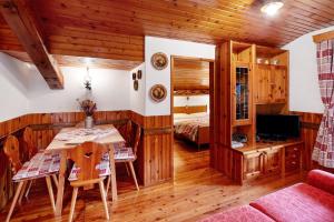 a bedroom with a bed and a table in a room at Appartamento Palmina in Falcade