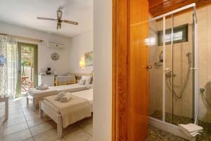 a bathroom with a shower and a living room at Nontas Home 20 in Kalamitsi