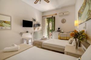 a hotel room with two beds and a window at Nontas Home 20 in Kalamitsi