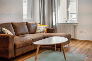 a living room with a brown couch and a table at Stadtzimmer Im Entenmoos in Bad Waldsee