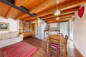 a kitchen and living room with a table and a couch at Villa Cleila Blu D in San Vito di Cadore