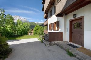 a house with a wooden door and a driveway at Villa Cleila Blu D in San Vito di Cadore