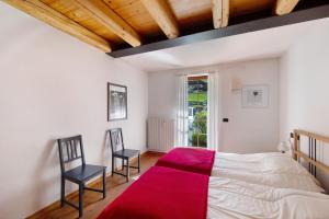 a bedroom with a bed and two chairs in it at Villa Cleila Blu D in San Vito di Cadore