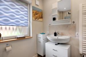 a bathroom with a sink and a window at Ferienhaus Apfelzauber in Twielenfleth +20 photos