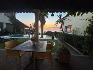 a table and chairs on a patio with a view of the ocean at Bela Vigia in Jardim do Mar