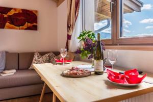 a table with a bottle of wine and wine glasses at Huberhof Appzimmer in Feldthurns