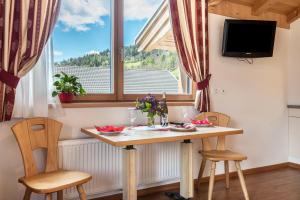 a dining room with a table and chairs and a window at Huberhof Appzimmer in Feldthurns