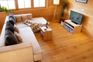 a living room with a large couch and a television at Ferienwohnung Naturnah in Dalaas