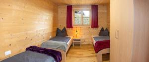 a room with two beds in a log cabin at Ferienwohnung Naturnah in Dalaas