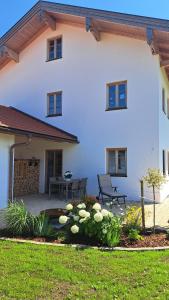 a white house with a patio and a table at Ferienwohnung z'Dandlberg in Tittmoning