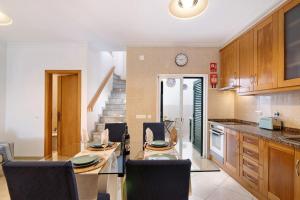 a kitchen with a table and chairs and a clock at Casa Mar-a-vila in Olhão +20 photos