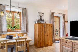 a dining room with a table and a television at Ferienwohnung z'Dandlberg in Tittmoning