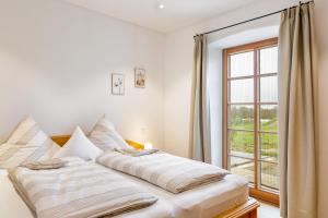 a bedroom with a large bed with a window at Ferienwohnung z'Dandlberg in Tittmoning