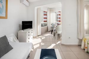 a white living room with a couch and a tv at Estudios 88 in Torrox