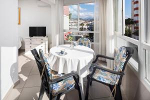 a table and chairs in a room with a window at Estudios 88 in Torrox