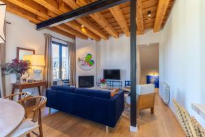 a living room with a blue couch and a table at Rio Tío Cocinas in La Granja de San Ildefonso
