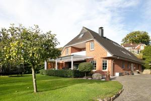 a brown brick house with a tree in the yard at Kleine Nock in Burg