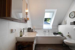 a white bathroom with a sink and a bath tub at Kleine Nock in Burg +19 photos