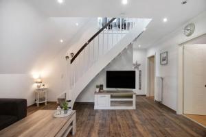a living room with a tv and a staircase at Kleine Nock in Burg