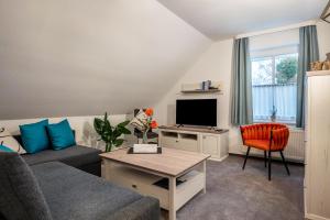 a living room with a couch and a tv at Ferienwohnung 2 Soltau in Soltau
