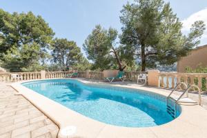 a swimming pool with a fence and trees at Montemar 36 in Port de Soller