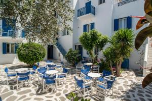 a patio with tables and chairs in front of a building at Adelfia Studios in Parikia