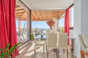 a dining room with red curtains and a table and chairs at Argali Beach Almuñecar in Almuñécar