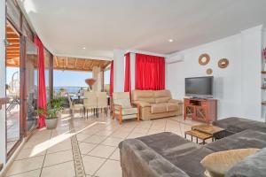 a living room with a couch and a television at Argali Beach Almuñecar in Almuñécar