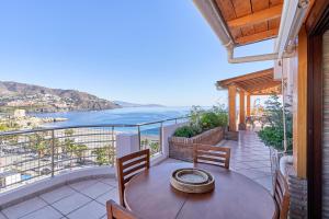 a table and chairs on a balcony with a view of the ocean at Argali Beach Almuñecar in Almuñécar