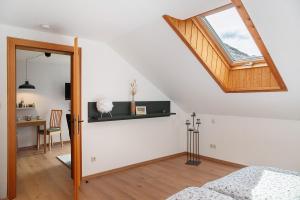 a bedroom with a skylight and a bed and a desk at Ferienwohnung Reschbergwies'n in Farchant