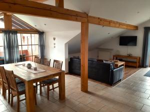 a living room with a table and a couch at Fewo beim Schmied Straßkirchen in Vogtareuth