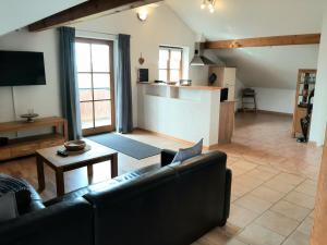 a living room with a couch and a kitchen at Fewo beim Schmied Straßkirchen in Vogtareuth