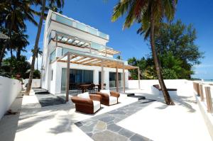 a house on the beach with palm trees at Amani Home - Moja Private Beach Suite in Kiwengwa